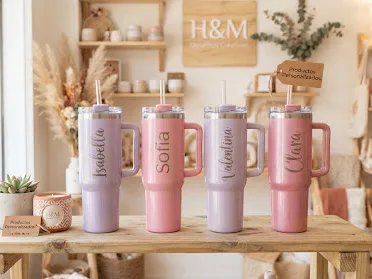 Estante del taller con termos personalizados en rosa y lila.